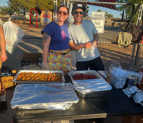 Volunteers smile in front of meal